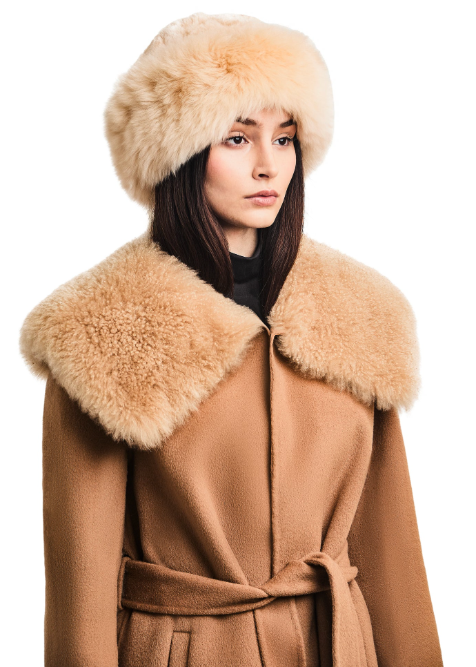 Model wearing Titicaca’s champagne Altiplano alpaca-fur ski hat with a rounded silhouette.