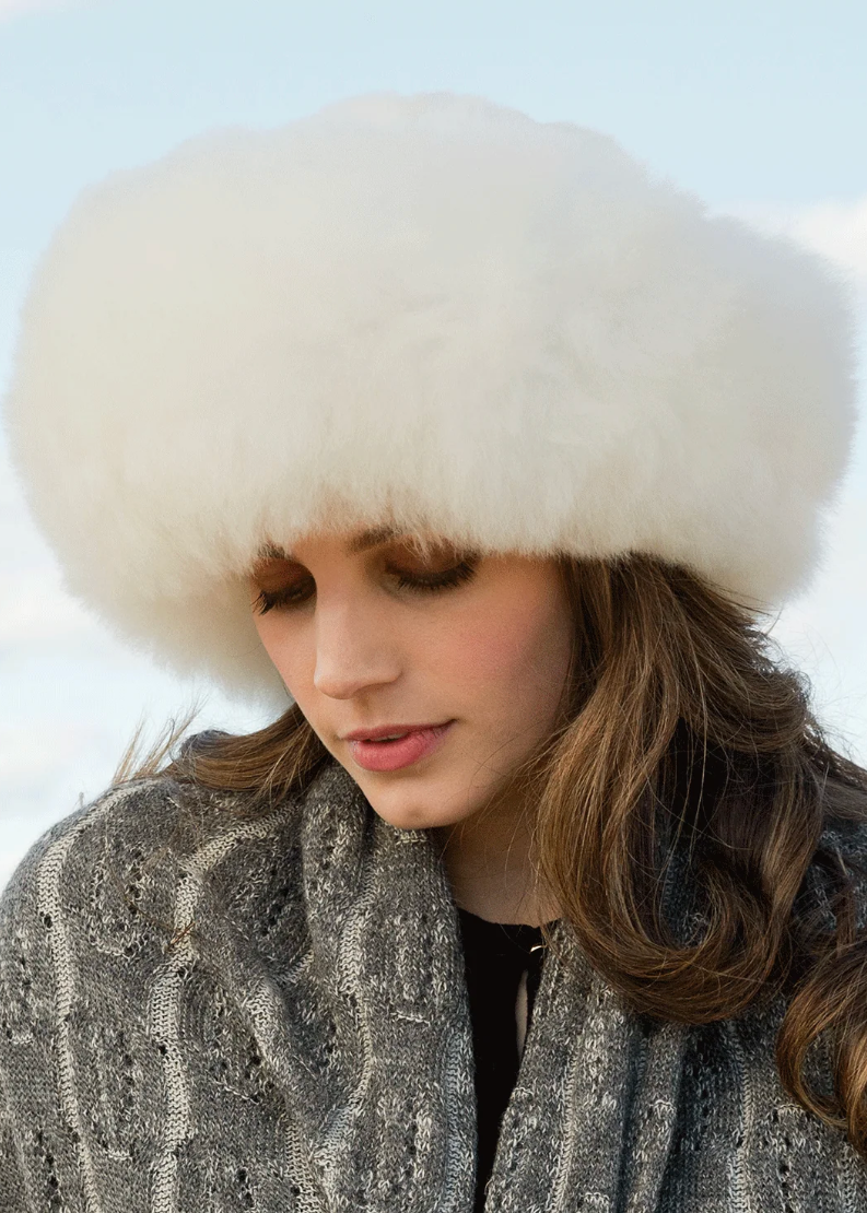 Model wearing Titicaca’s champagne Altiplano alpaca-fur ski hat with a rounded silhouette.