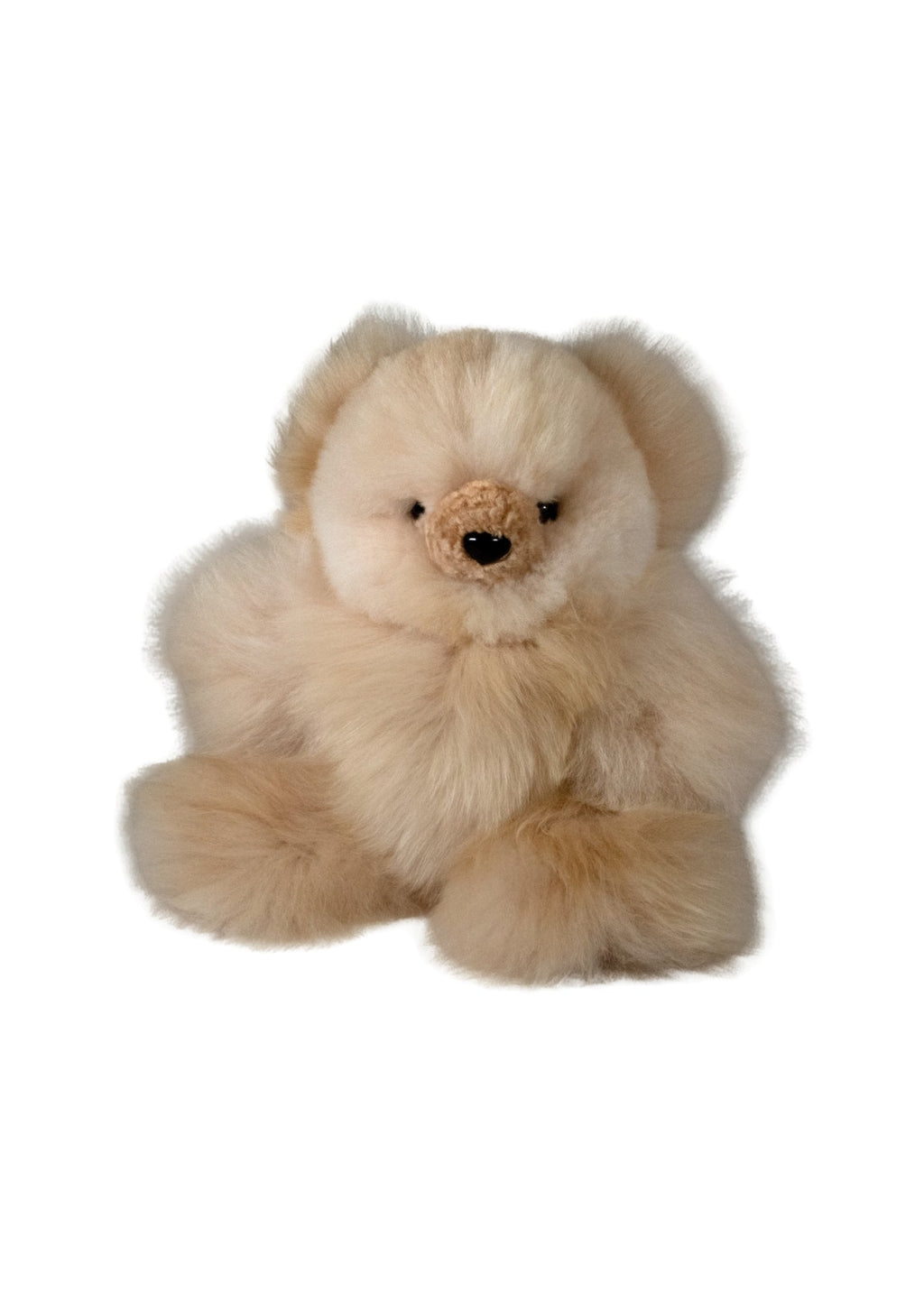 A fluffy cream-colored teddy bear plush toy made of a soft alpca fur, small black eyes, and a stitched brown nose, shown against a plain white background.
