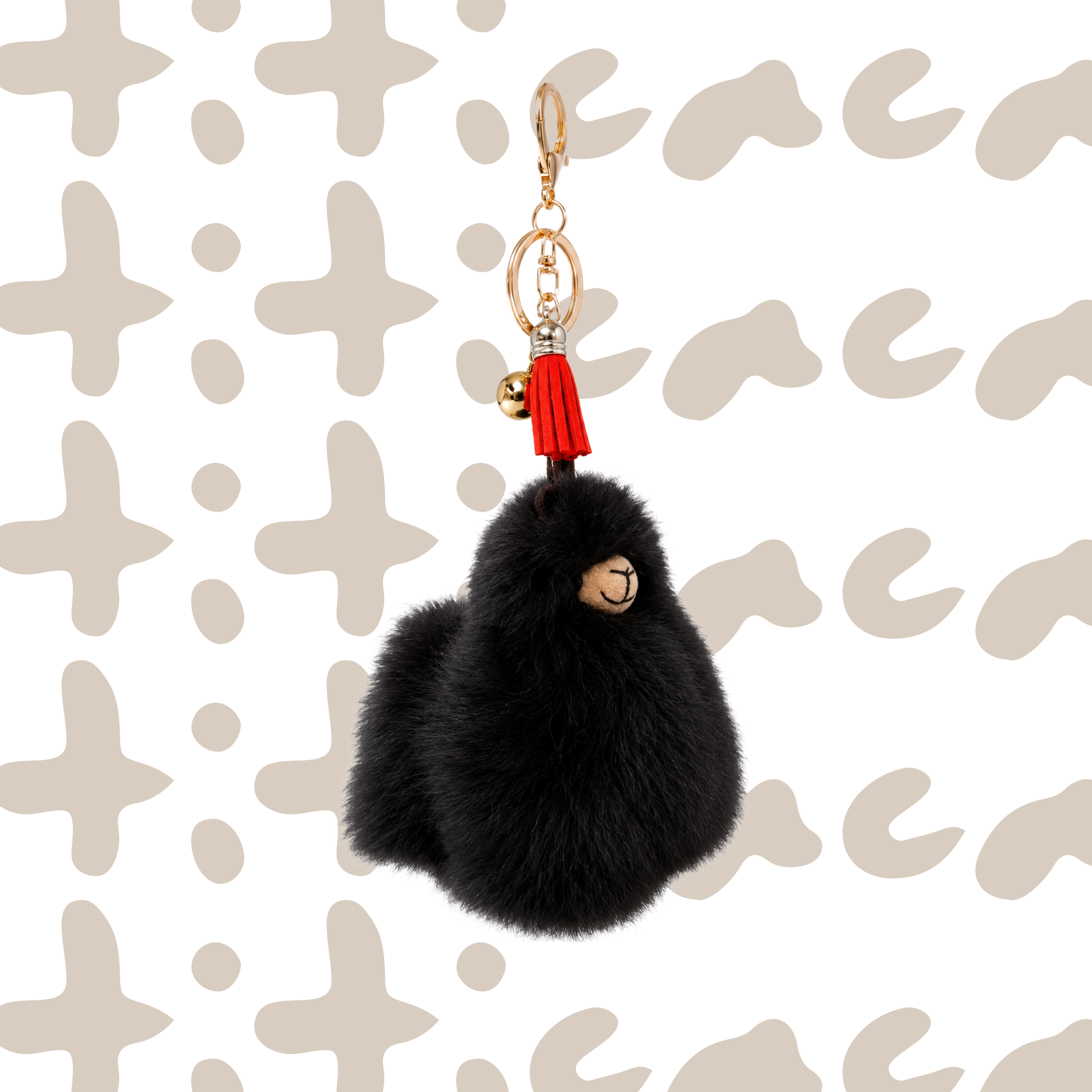 A black fluffy alpaca keychain charm with a gold-tone metal clasp, a red tassel, and a small gold bell, shown against a white background with a light beige pattern.