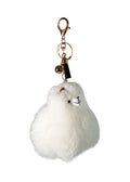 A fluffy white alpaca keychain charm with a small embroidered face, black tassel, and gold-tone clasp and bell, shown on a plain white background.